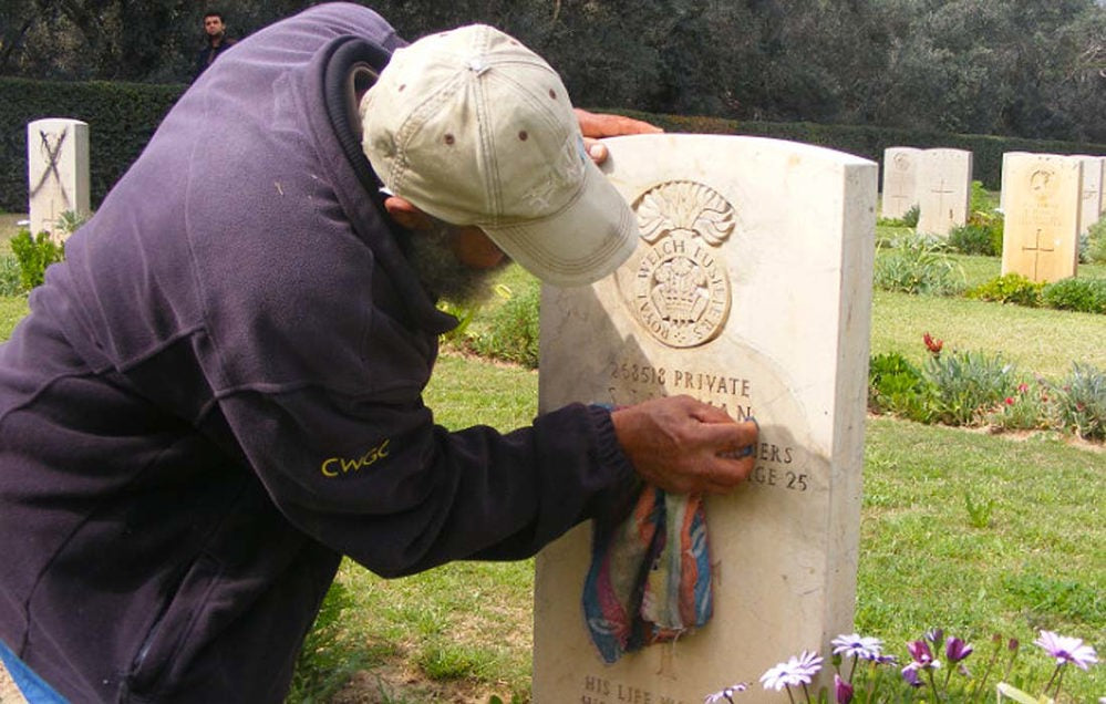 Man cleaning headstone